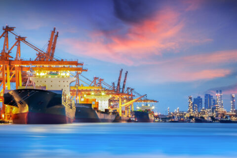 Container Cargo freight ship with working crane bridge in shipyard at dusk for Logistic Import Export background